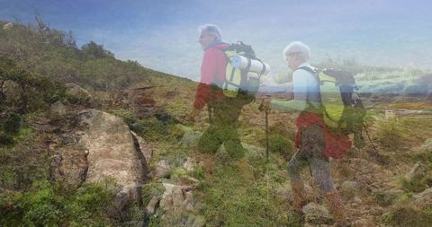 Senior hikers exploring rugged mountain trail with backpacks