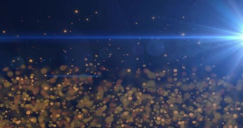 Golden bokeh particle field with cool blue lens flare and festive cinematic glow
