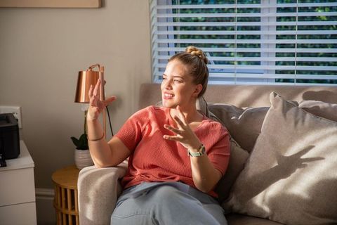 Woman relaxing on sofa in sunlit living room