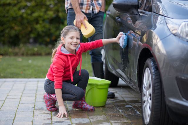 Teenage girl washing a car on a sunny day - Download Free Stock Photos Pikwizard.com