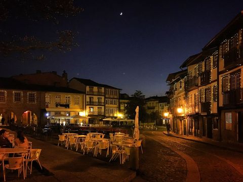 Moonlit European Square with Empty Outdoor Cafe Terraces, Cobblestone Street and Warm Lights
