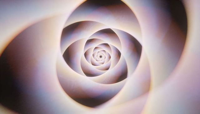 Swirling pastel spiral vortex featuring layered paper texture and soft gradient lighting