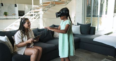 Mother and Daughter Exploring Virtual Reality Together at Home