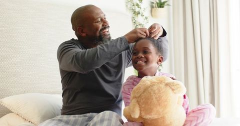 Father Braiding Daughter's Hair During Relaxed Family Moment