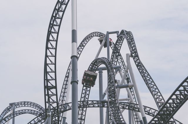 This image shows a roller coaster ride with looping tracks in an amusement park. Ideal for advertising amusement parks, thrill rides, or family vacations. Perfect for illustrating travel blogs, brochures, or adventure tourism campaigns.