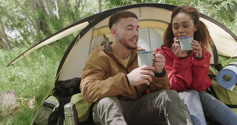 Happy Camping Couple Enjoying Coffee in Lush Forest