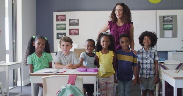 Group of diverse young students smiling with their teacher in a classroom setting, ideal for depicting educational themes, school learning activities, multicultural teamwork, and the joyful school environment. Perfect for educational publications, school websites, and promotional materials for educational programs.