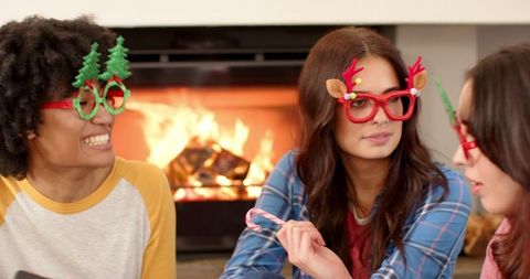 Diverse Friends Enjoying Holiday Spirit with Novelty Glasses by Fireplace