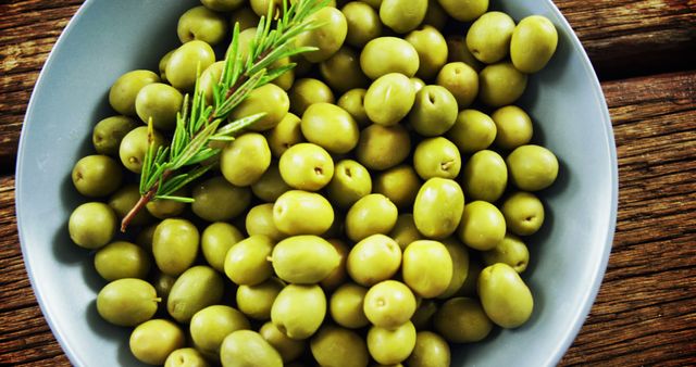 Close-up of Fresh Green Olives in Bowl with Rosemary Garnish - Download Free Stock Images Pikwizard.com