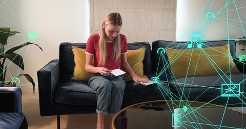 Placing note cards on velvet sofa while smart home network lines connecting devices glowing