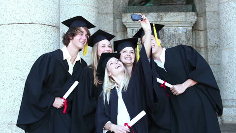 Group of Happy Graduates Taking Selfie in Front of University