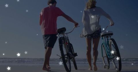 Couple Enjoying Leisurely Beach Walk with Bicycles at Sunset