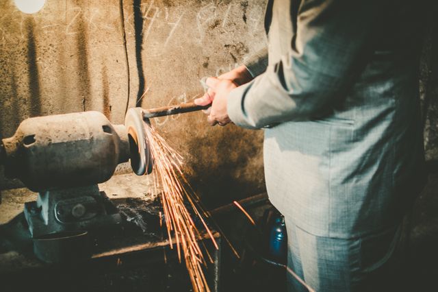 Man Grinding Metal with Sparks in Industrial Workshop - Download Free Stock Images Pikwizard.com