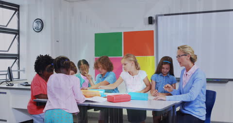 Children Collaborating on Project with Teacher in Classroom