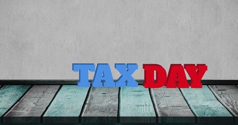Tax day concept with colorful block letters on wooden floor