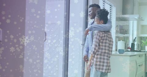 Couple Embracing While Watching Falling Snow from Home