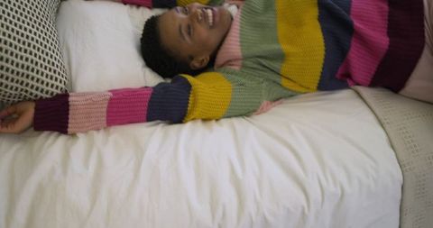Woman Resting Cozy in Striped Sweater on Bed
