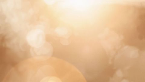 Golden Sun Halo with Orange Lens Flare and Soft Bokeh Abstract Background