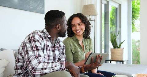Couple Bonding in Bright Living Room with Tablet and Coffee