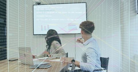 Young professionals presenting data and collaborating in boardroom with digital overlay