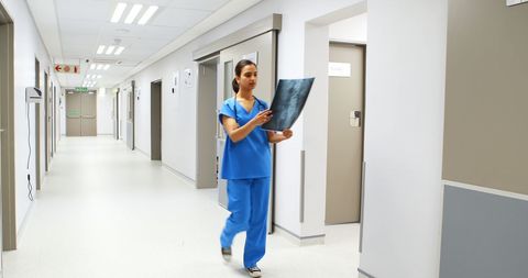 Female Doctor Analyzing X-Ray in Modern Hospital Hallway - Download Free Stock Images Pikwizard.com