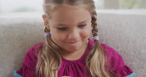 Smiling Young Girl with Braided Hair Reading at Home