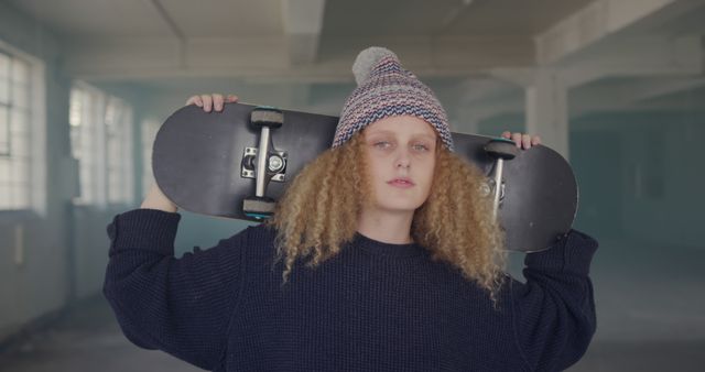 Confident Teenage Girl Holding Skateboard in Urban Warehouse - Download Free Stock Images Pikwizard.com