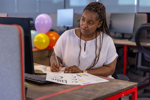 Professional woman analyzing data at office desk