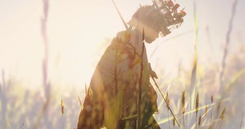 Woman Hiking in Mountains at Sunrise Silhouetted by Tall Grass
