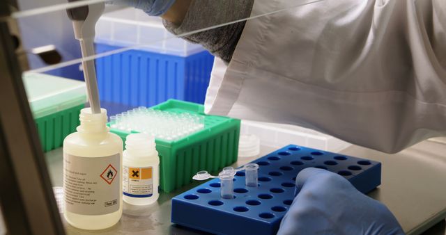 Scientist using pipette to dispense liquid into test tubes in a laboratory setting, conducting important research. This image can be used for educational materials, scientific publications, lab safety manuals, or biotechnology presentations.