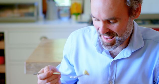 Man with beard eating healthy meal in bright kitchen - Download Free Stock Images Pikwizard.com