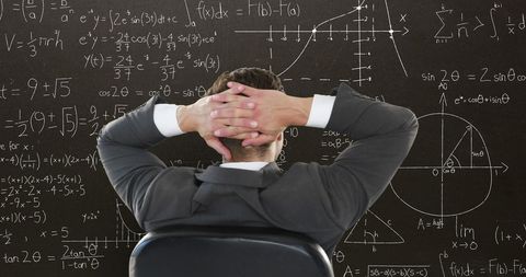 Man Seated Backwards Pondering Complex Mathematical Equations