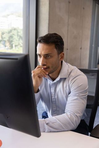 Focused professional man in office engaging with computer screen