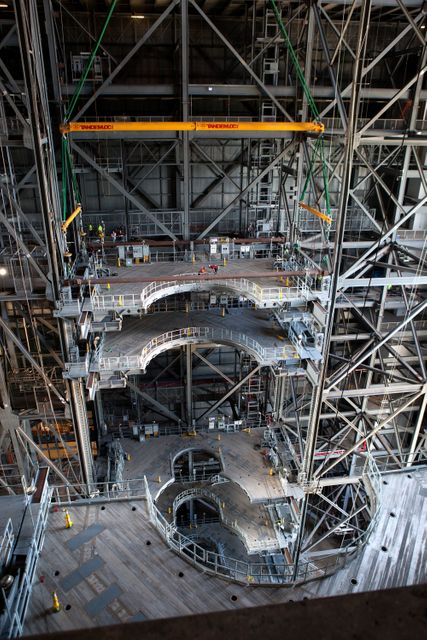 A heavy-lift crane lowers the second half of the D-level work platforms, D north, for NASA’s Space Launch System (SLS) rocket, into position for installation in High Bay 3 in the Vehicle Assembly Building (VAB) at the agency’s Kennedy Space Center in Florida. The platform will be installed on the north side of the high bay. The D platforms are the seventh of 10 levels of work platforms that will surround and provide access to the SLS rocket and Orion spacecraft for Exploration Mission 1. The Ground Systems Development and Operations Program is overseeing upgrades and modifications to VAB High Bay 3, including installation of the new work platforms, to prepare for NASA’s journey to Mars. 