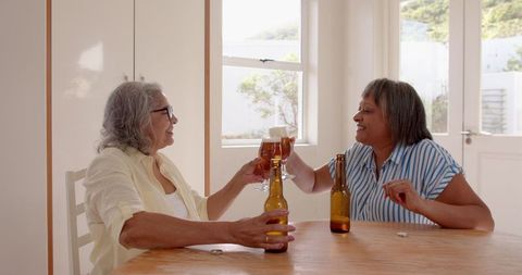 Senior Friends Celebrating at Home with Drinks and Laughter