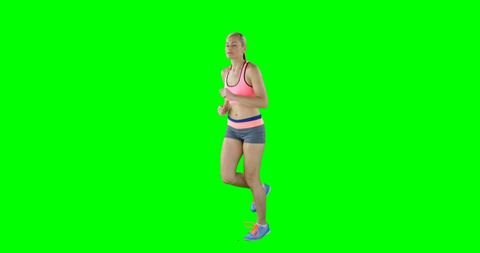Athletic woman running on green screen
