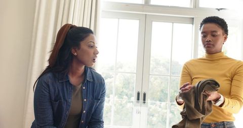 Diverse Friends Folding Clothes in Sunlit Modern Room