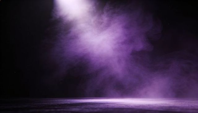 Purple spotlight illuminating smoky stage with low mist and reflective floor