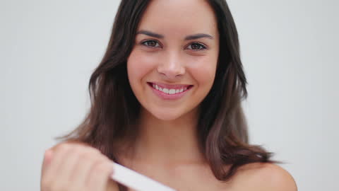 Smiling Woman Filing Nails in Minimalist Setting