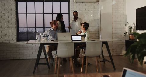 Energetic team collaboration in modern evening office