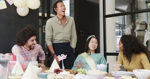 Multiracial colleagues celebrating baby shower at office