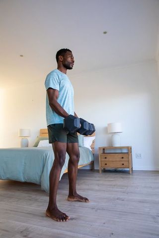 Home Fitness Routine with Dumbbells in Minimalist Bedroom