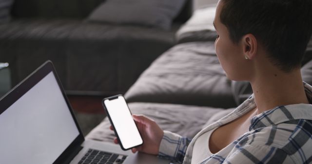 Young Woman Multitasking with Smartphone and Laptop in Living Room - Download Free Stock Images Pikwizard.com