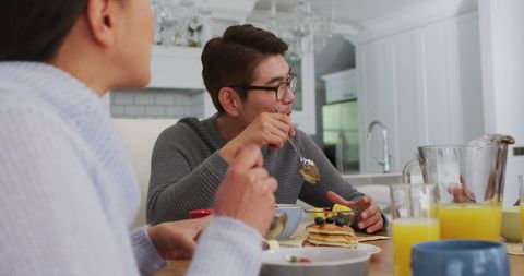 Family Enjoying Breakfast Together at Home in Kitchen