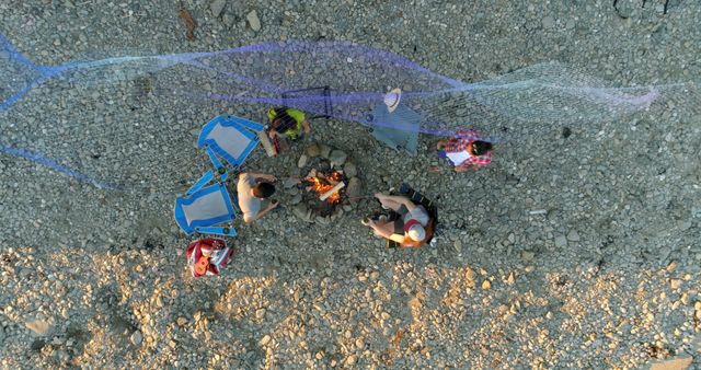 Group of Friends Sitting Around Campfire on Rocky Beach, Aerial View - Download Free Stock Images Pikwizard.com