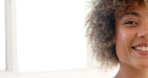 Close-Up of Young Woman with Curly Hair Smiling Brightly