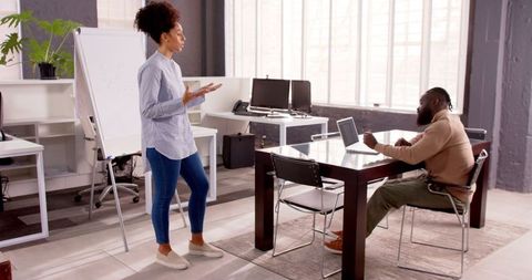 Colleagues Discussing Project Ideas in Modern Office Environment