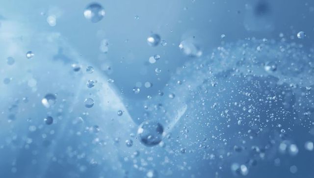 Macro blue water droplets and microbubbles with bokeh reflections and backlit spheres