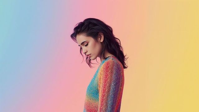 Posing woman wearing rainbow lace dress on pastel gradient background, fashion portrait