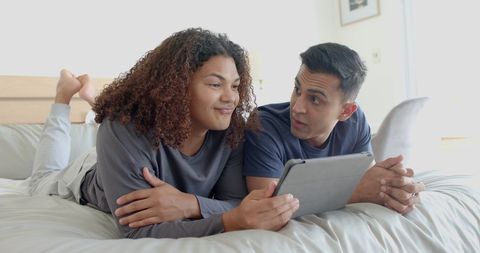 Happy Diverse Gay Couple Using Tablet on Bed at Home - Download Free Stock Images Pikwizard.com
